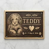 Bronze Memorial plaque for a dog named Teddy with engraved text and illustrations on a marble background