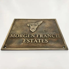 Bronze plaque with a dog illustration and 'Morgen Franch Estates' text on a white background