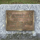 Bronze plaque on a stone wall with engraved text in memory of Terry G Salas.