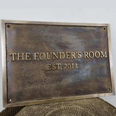Bronze plaque with custom text on a textured surface.