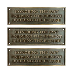 Three bronze plaques with engraved text on a white background