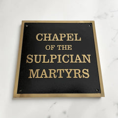Custom Bronze Sign with 'Chapel of the Sulpician Martyrs' text on a black background with gold lettering.