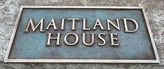 Bronze address sign with 'MAITLAND HOUSE' text on a textured background