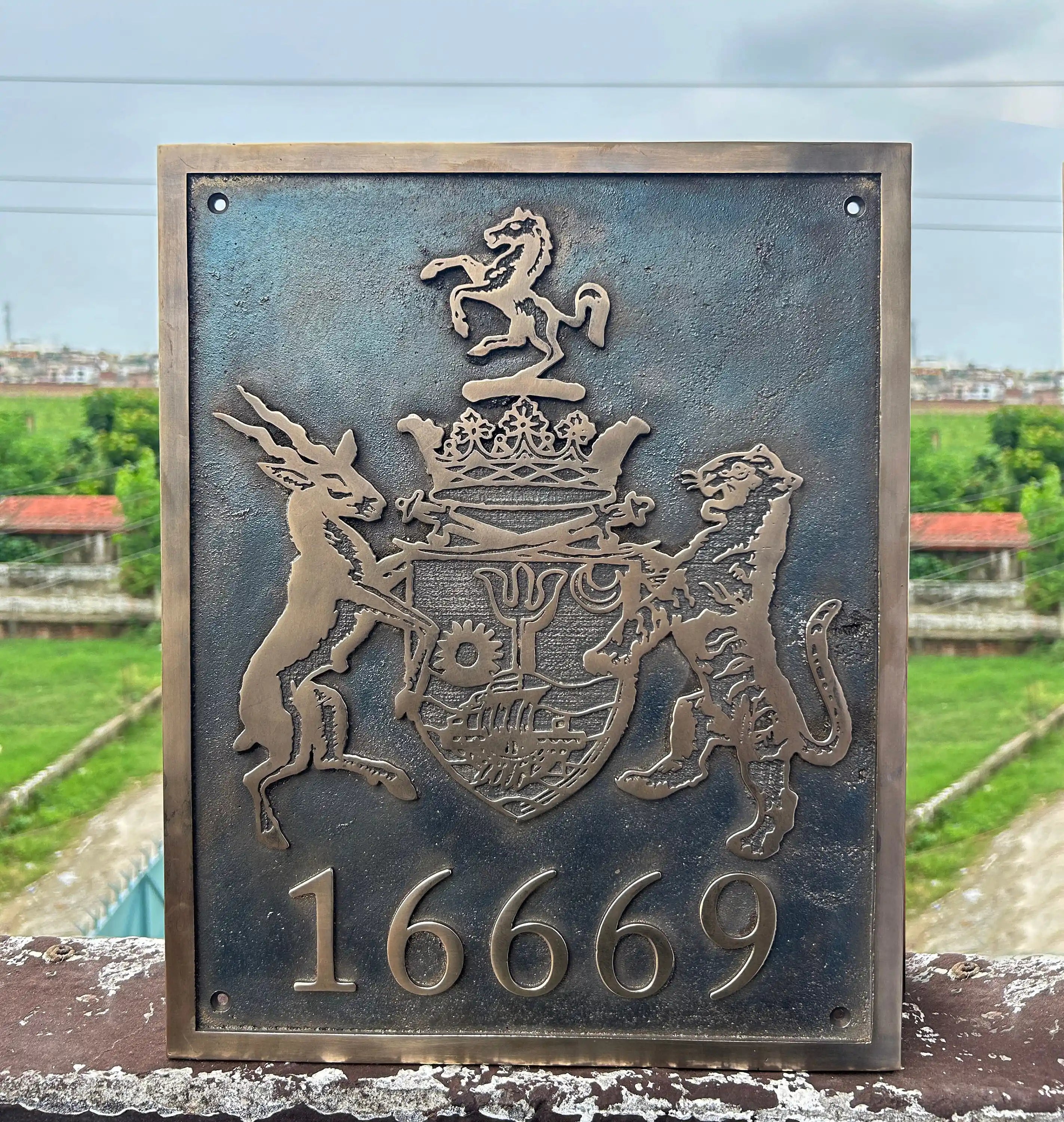 Decorative plaque with a coat of arms and number '16669' against a blurred outdoor background