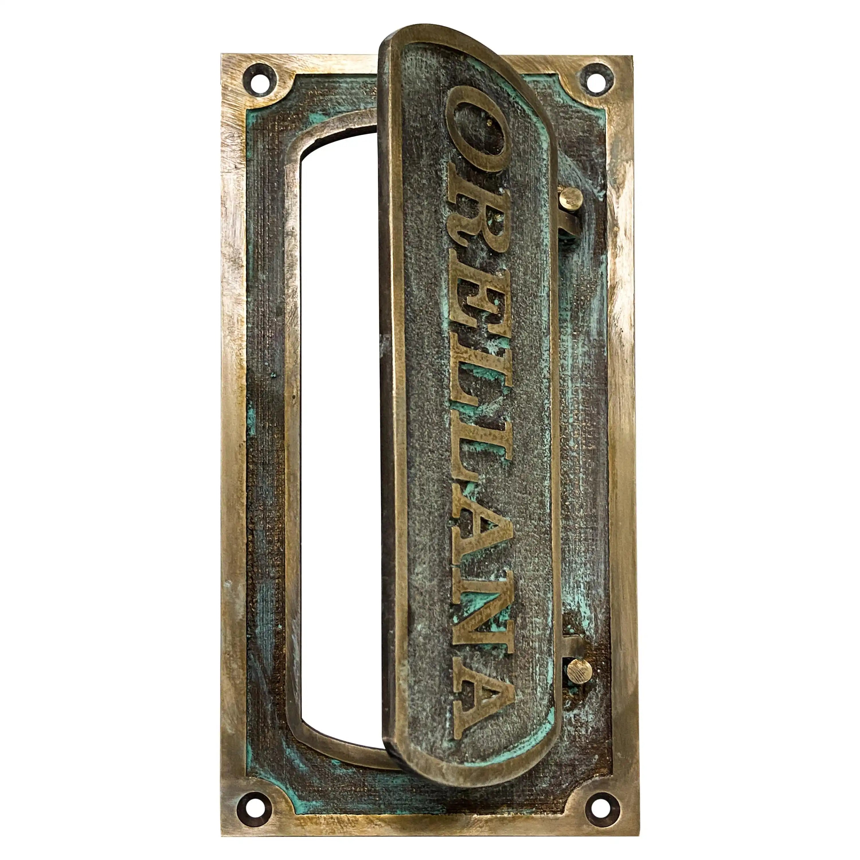 Brass mail slot for door installed on wooden front door exterior