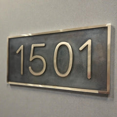 Bronze house number plaque - House number sign '1501' on a gray wall