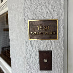 Bronze house number plaque with polished raised lettering - Address plaque on a textured wall with '1530 Avalon Place' text