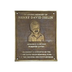 A rectangular bronze memorial plaque with rounded corners, featuring an engraved portrait of a young boy and personalized text reading 'In Loving Memory of Henry David Iselin' and 'Forever Loved,' on a plain white background.