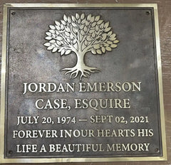 Memorial plaque with a tree design and engraved text on a metallic background