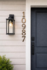 Vertical solid bronze address numbers in an oil rubbed bronze finish mounted on a wall