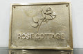 Brass plaque with 'Rose Cottage' and a rose design on a white background