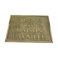 Brass plaque with 'MAISON LAVAILLE' text and logo on a white background