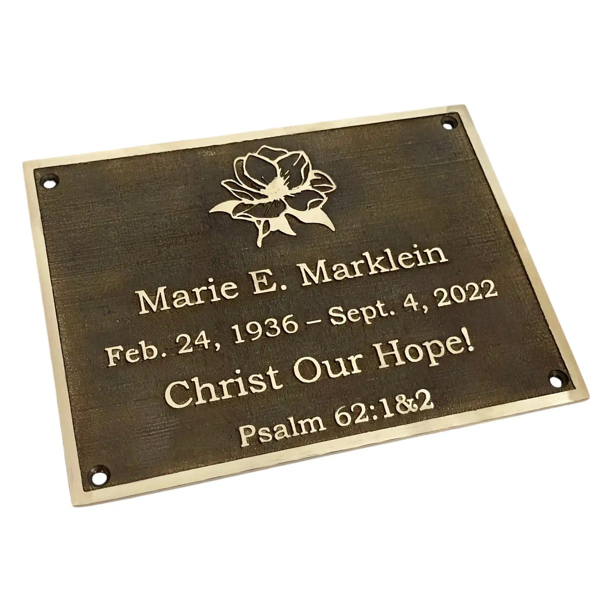 Memorial plaque with engraved text and a flower design on a white background