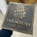 Decorative Bronze sign with rose design and 'The Mount Est 2021' text