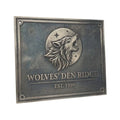 Bronze plaque with a wolf emblem and 'Wolves' Den Ridge' text on a white background
