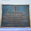 Memorial plaque for John David Broughton with a Celtic cross design on a blue background.
