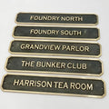 Bronze signs with engraved names on a white background