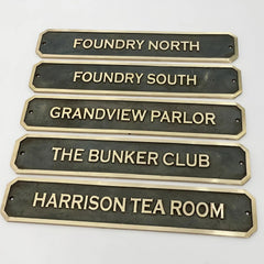 Bronze signs with engraved names on a white background