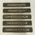 Set of bronze nameplates with gold text on a white background