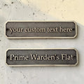 Two customizable nameplates on a textured surface