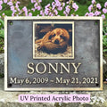 Memorial plaque with a photo of a dog named Sonny and his lifespan, set against a natural background.