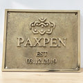 Cast Bronze/Brass custom signs & plaques - Brass plaque with 'PAXPEN' logo and establishment date on a white background