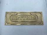 Brass letter box plate with 'LETTERS' engraved on a light gray background