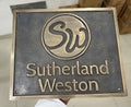 bronze plaque with 'Sutherland Weston' branding on a neutral background