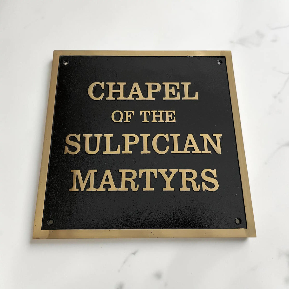 Custom Bronze Sign with 'Chapel of the Sulpician Martyrs' text on a black background with gold lettering.