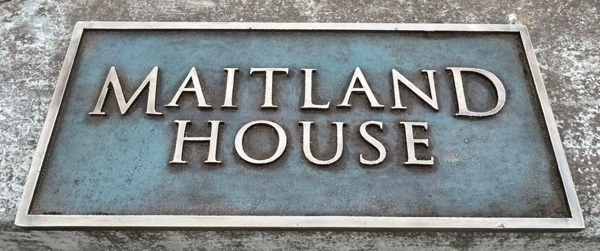 Bronze address sign with 'MAITLAND HOUSE' text on a textured background