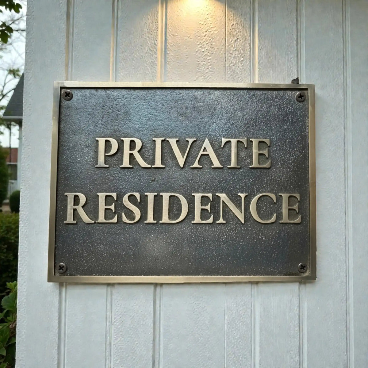 Bronze sign on a wooden wall with 'PRIVATE RESIDENCE' text