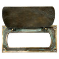 Close up detail of antique brass mail slot flap mechanism