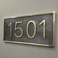 Bronze house number plaque - House number sign '1501' on a gray wall