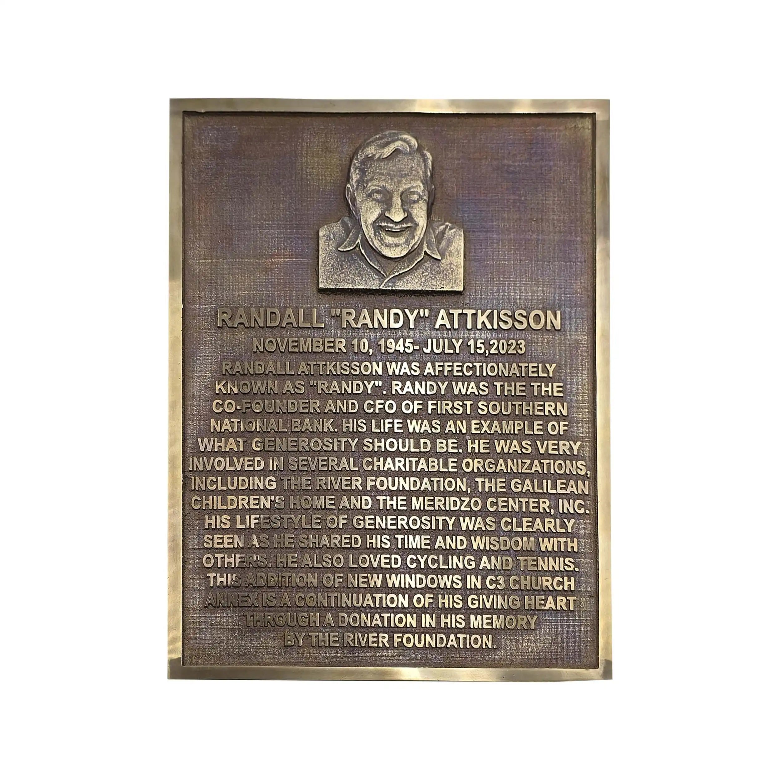 A rectangular bronze memorial plaque with a raised portrait at the top and engraved text honoring Randall 'Randy' Atkisson, shown on a plain white background.