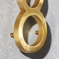 Custom solid brass building address numbers designed with a three-dimensional floating effect and concealed mounting.