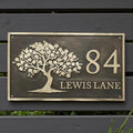 Decorative house number sign with tree design on a wooden background - handcrafted bronze house number plaque