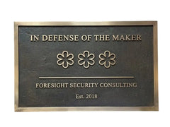 Bronze Plaque with 'In Defense of the Maker' and 'Foresight Security Consulting' text on a white background