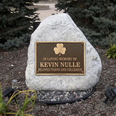 Memorial bronze plaque with a stone honoring Kevin Nulle in a garden setting.