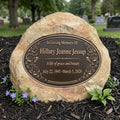 Memorial stone with bronze plaque in a cemetery