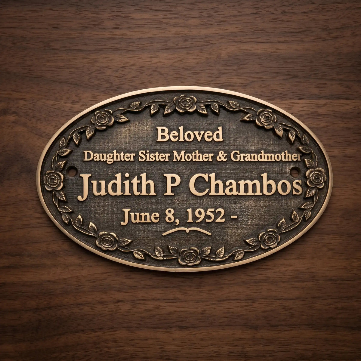 Bronze plaque with engraved text on a wooden background
