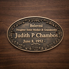 Bronze plaque with engraved text on a wooden background