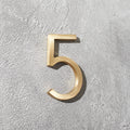 Modern solid brass house numbers featuring concealed stud mounting for a clean floating appearance.