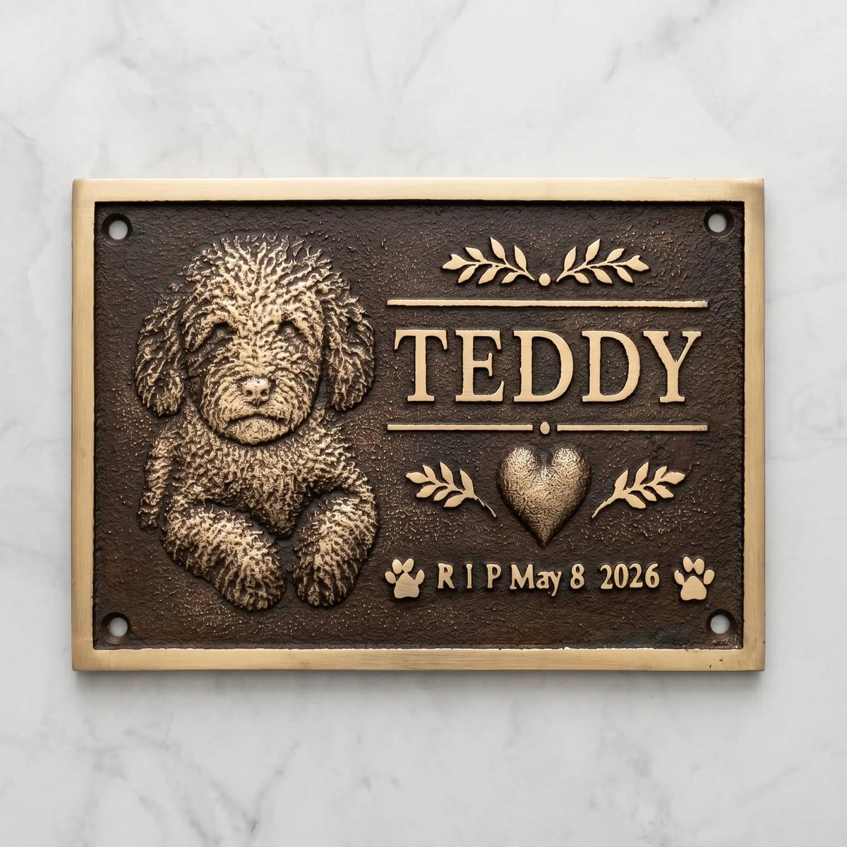 Bronze Memorial plaque for a dog named Teddy with a heart and dates on a marble background